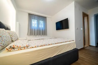a bedroom with a bed with a television on the wall at Vila Vrnjačka Banja in Vrnjačka Banja