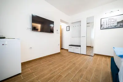 a living room with white walls and a wooden floor at Vila Vrnjačka Banja in Vrnjačka Banja