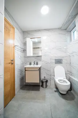 a white bathroom with a toilet and a sink at Vila Vrnjačka Banja in Vrnjačka Banja