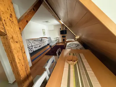 a room with a table and two beds in a room at Konaci Spacious Studio in the Heart of the Slopes in Kopaonik