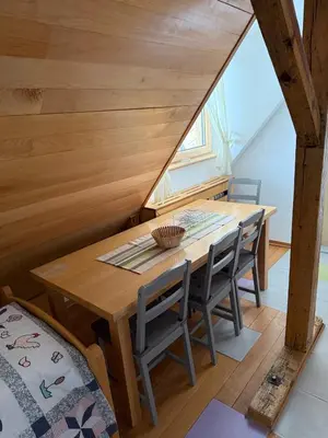 a dining room with a wooden table and chairs at Konaci Spacious Studio in the Heart of the Slopes in Kopaonik
