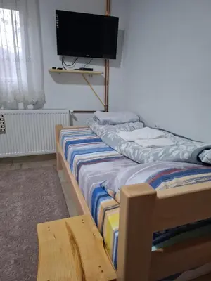 a bedroom with two beds and a tv on the wall at PODNOZJe KOPAONIKA in Brus