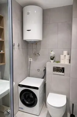 a small bathroom with a washing machine and a toilet at Leo Lux 3 in Niš