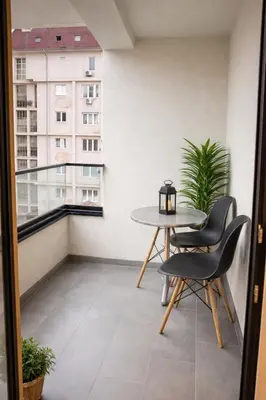 a balcony with a table and chairs and a window at Leo Lux 3 in Niš