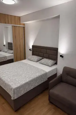 a bedroom with a bed and a couch at Leo Lux 3 in Niš