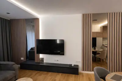 a living room with a flat screen tv on a wall at Leo Lux 3 in Niš
