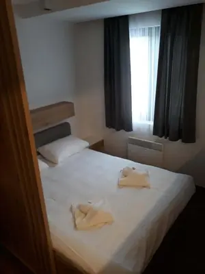a bedroom with two towels on a bed with a window at Blue Sky in Bukorovac
