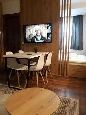 a living room with a table and chairs and a tv at Blue Sky in Bukorovac