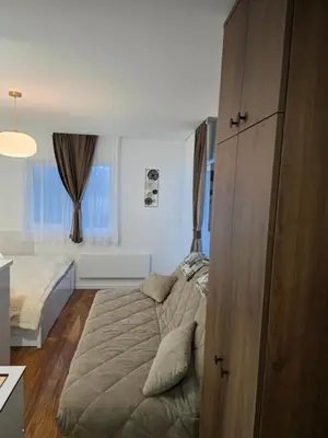 a bedroom with a bed and a large wooden cabinet at Sky Nest Kopaonik in Kopaonik