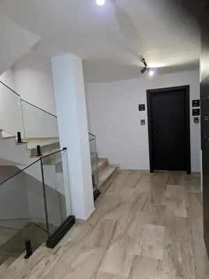 a hallway with a black door and a wooden floor at Sky Nest Kopaonik in Kopaonik