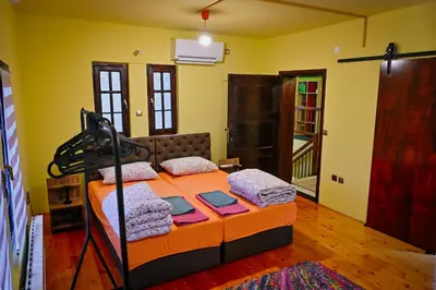 a bedroom with a bed in a room with yellow walls at Vila369 in Pirot
