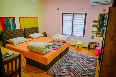 a bedroom with two beds and a rug at Vila369 in Pirot