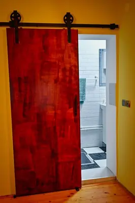 a red door in a room with a bathroom at Vila369 in Pirot