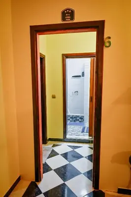 a hallway with a mirror and a checkered floor at Vila369 in Pirot