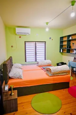 a bedroom with a large bed with an orange bedspread at Vila369 in Pirot