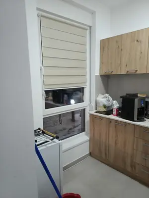 a kitchen with a window with a blind at Apartman Leontina Vrnjačka Banja in Vrnjci