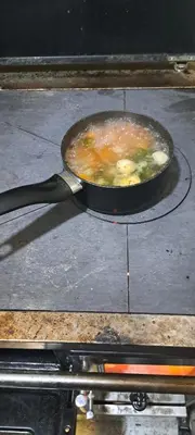 a pan of food sitting on top of a stove at Koliba boema in Despotovac