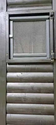 a metal door with a window on a building at Koliba boema in Despotovac