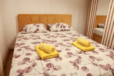 a bed with two yellow towels on top of it at Apartman Wish Lux in Vrnjci