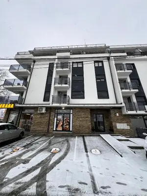 a large building with snow on the ground in front of it at Apartman Wish Lux in Vrnjci