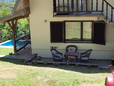 a house with chairs and a porch with a pool at Kalina in Vlasina Okruglica