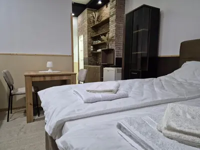 a bedroom with a bed and a table and a desk at Niš Residence in Niš