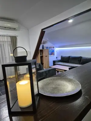 a candle sitting on a table in a living room at Niš Residence in Niš