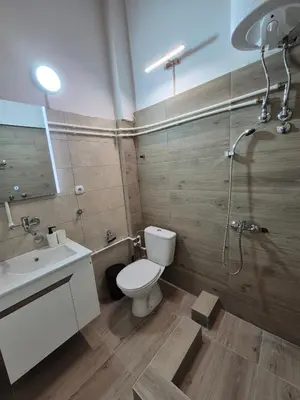 a bathroom with a toilet and a sink and a shower at Niš Residence in Niš