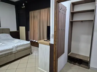 a bedroom with a bed and a desk with a bed and a closet at Niš Residence in Niš