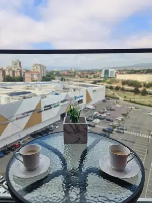 two cups of coffee on a glass table on a balcony at Planet Residence Deluxe Wellnes & Spa Apartment in Niš