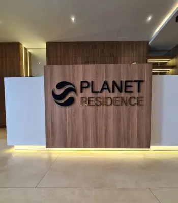a wooden sign for a planetresistancehibition in a building at Planet Residence Deluxe Wellnes & Spa Apartment in Niš