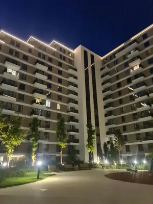 a large white apartment building at night at Planet Residence Deluxe Wellnes & Spa Apartment in Niš