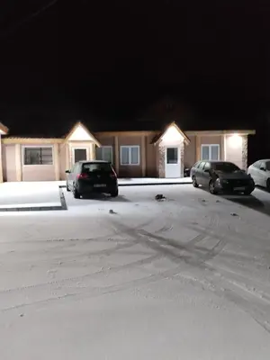 two cars parked in a parking lot at night at Etno kuca Brzece in Brzeće