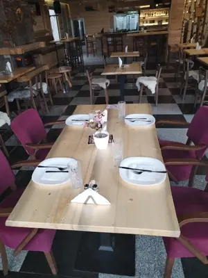 a long wooden table in a restaurant with purple chairs at Etno kuca Brzece in Brzeće