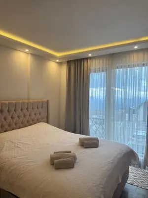 a bedroom with a bed with two towels on it at RASH Apartman in Kopaonik