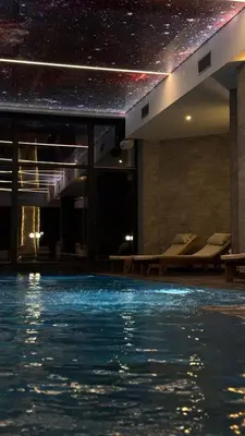 a swimming pool in a building with a star ceiling at RASH Apartman in Kopaonik