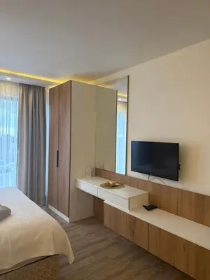 a bedroom with a bed and a tv on a wall at RASH Apartman in Kopaonik