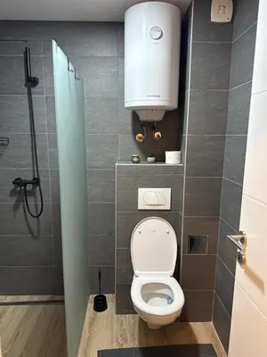 a small bathroom with a toilet with a tank at RASH Apartman in Kopaonik