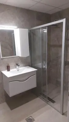 a bathroom with a white sink and a shower at Onix 1 in Soko Banja