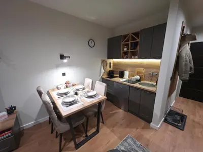 a kitchen with a table and chairs and a sink at Bela Reka 204 in Brzeće