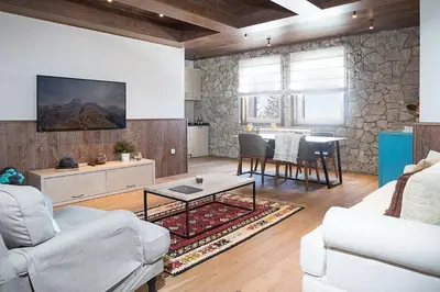 a living room with a couch and a table at Top Hill - Župa Kopaonik in Kopaonik