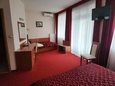 a hotel room with a bed and a desk and window at Motel Aleksandar in Pojate