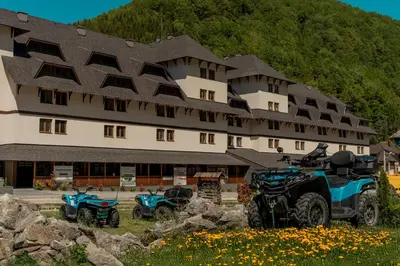 a building with two atvs parked in front of it at Apart-Hotel Bela Reka in Brzeće
