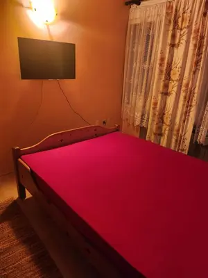 a bedroom with a red bed with a flat screen tv at Vila Vera Jastrebac in Buci