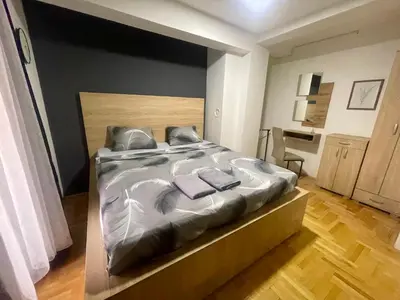 a bedroom with a large bed with two towels on it at Park Residence 1 in Niš