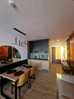 a kitchen and living room with a table and chairs at SkyLux Apartments Kopaonik - Residence Hill in Kopaonik