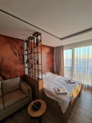 a bedroom with a large bed and a couch at SkyLux Apartments Kopaonik - Residence Hill in Kopaonik
