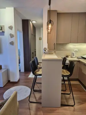 a kitchen and living room with a table and chairs at Avram in Vrnjci