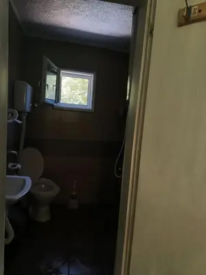 a bathroom with a toilet and a window at Vila Kruna