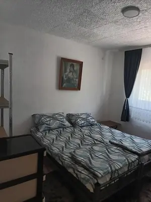 a bedroom with a bed and a picture on the wall at Vila Kruna
